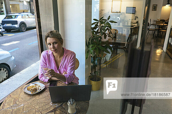 Freiberufler mit Laptop sitzt am Tisch im Café