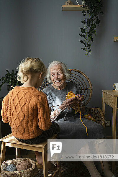 Glückliche Großmutter  die Enkelin zu Hause das Stricken beibringt