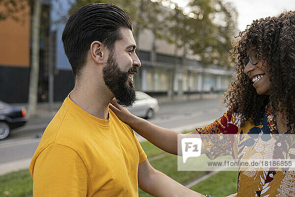 Happy young man with girlfriend standing at footpath