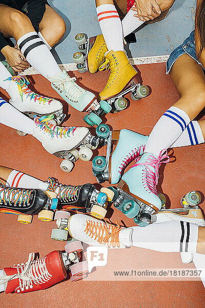 Beine von Frauen mit bunten Rollschuhen auf dem Sportplatz