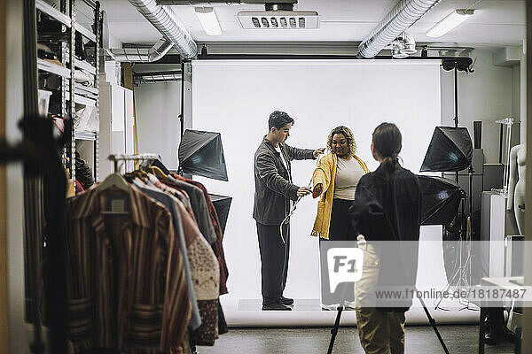 Männliches Design professionelle Messung Jacke von Mode-Modell während Foto-Shooting im Studio