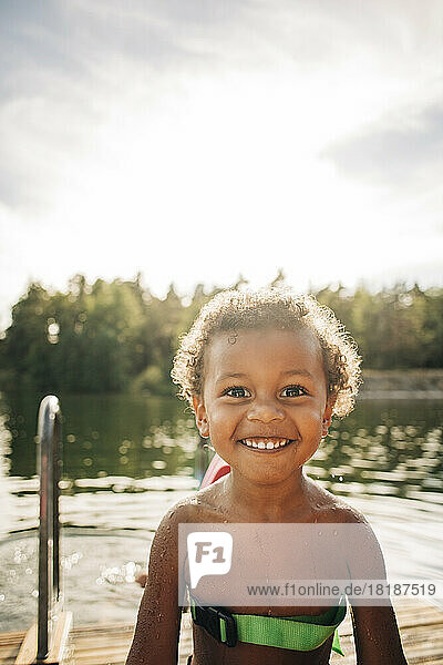Porträt eines hemdlosen  fröhlichen Jungen am See