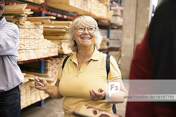 Glückliche ältere Frau mit Brille  die eine Verkäuferin in einem Eisenwarenladen ansieht