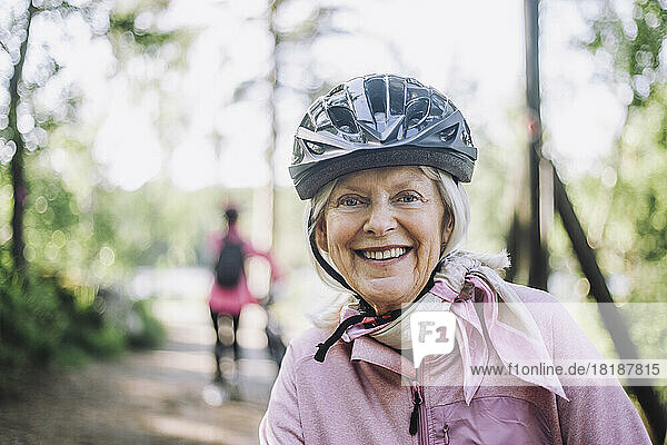 Porträt einer glücklichen älteren Frau mit Fahrradhelm