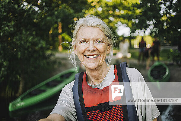 Porträt einer glücklichen älteren Frau mit Schwimmweste