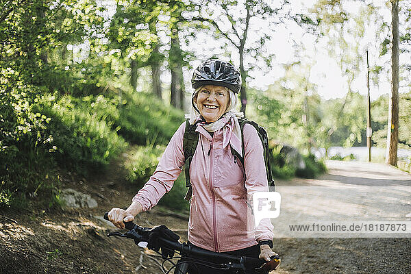 Porträt einer älteren Frau mit Fahrrad auf dem Fußweg