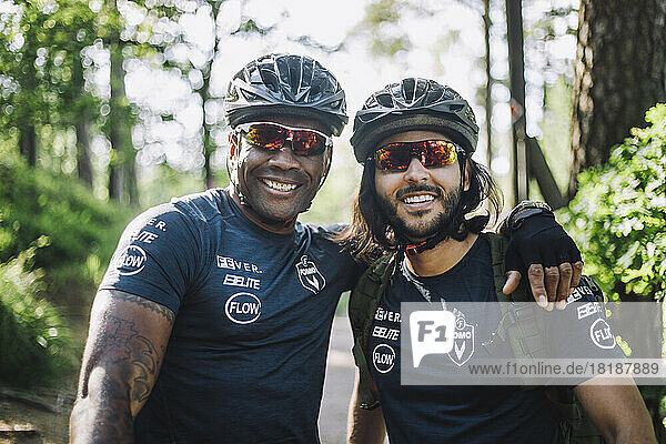 Lächelnder männlicher Radfahrer mit Schutzbrille und Helm