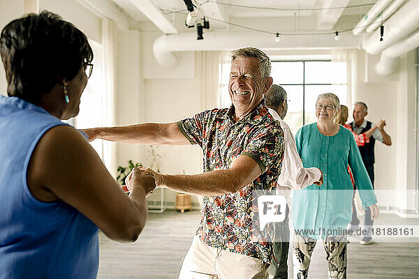 Glückliches multirassisches älteres Paar tanzt zusammen in der Klasse