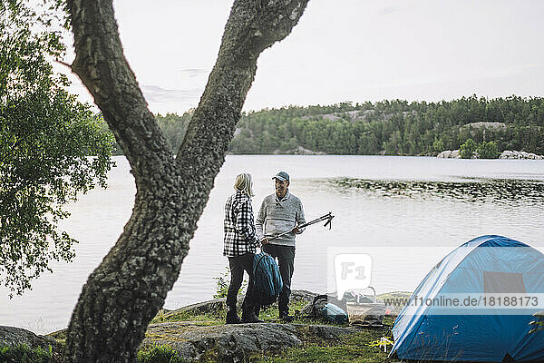 Älterer Mann im Gespräch mit einem Freund beim Camping am See