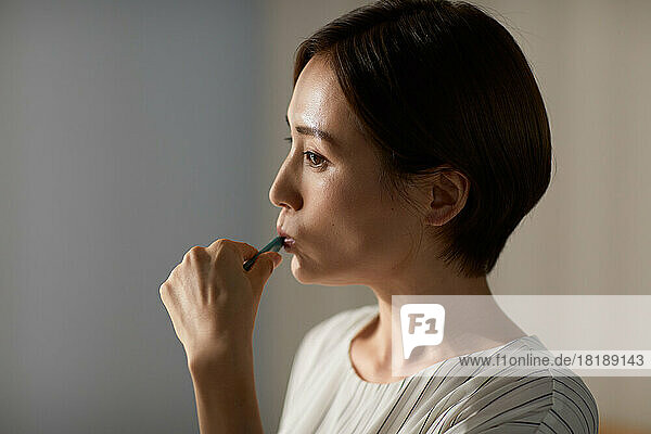 Japanese woman brushing teeth at home