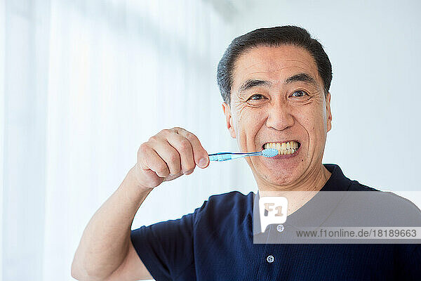 Japanese senior man brushing teeth