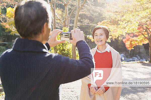 Senior Japanese couple traveling in the autumn leaves season