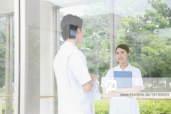Smiling young female nurse having a conversation in the hallway