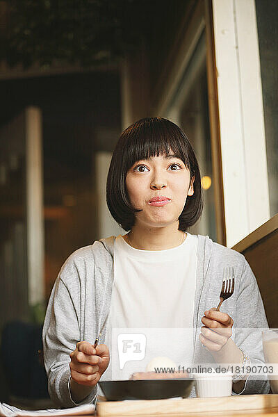 Young Japanese woman eating french toast