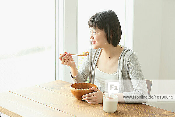 Young Japanese woman eating breakfast