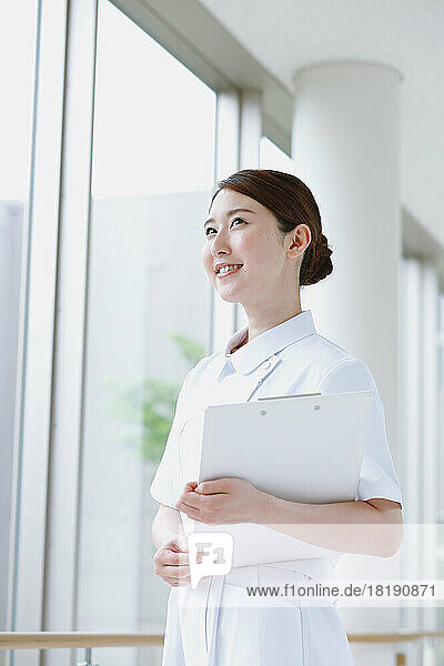 Smiling young Japanese female nurse in the hallway