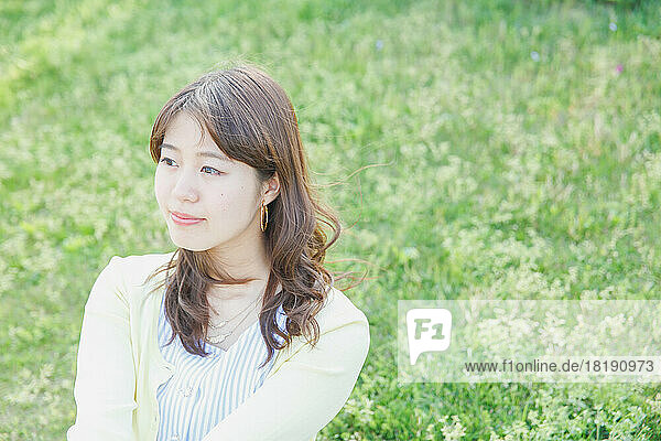Japanese woman relaxing on the grass