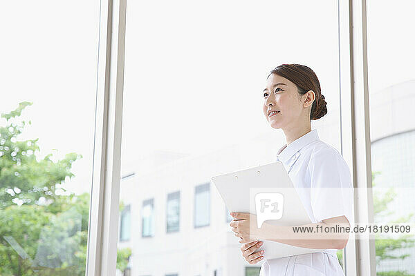 Young Japanese female nurse walking in the hallway