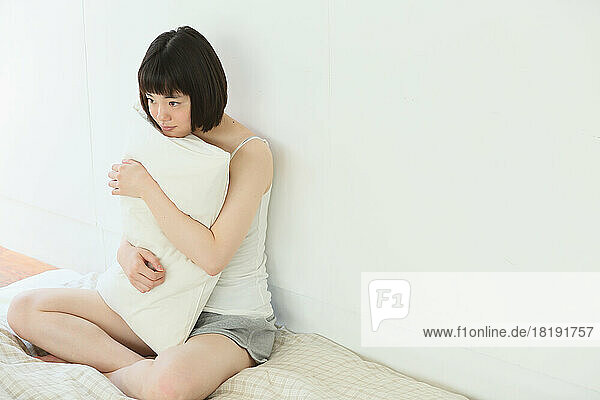 Young Japanese woman relaxing on bed