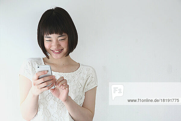 Young Japanese woman operating a mobile phone