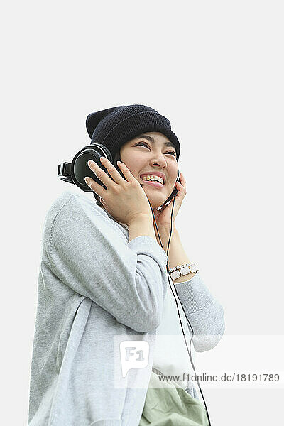 Young Japanese woman listening to music with headphones