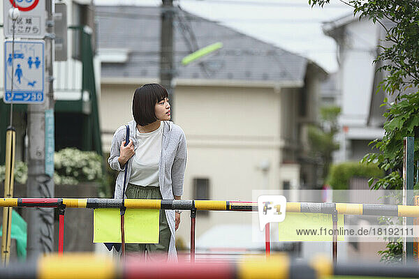 Young Japanese woman at a railroad crossing