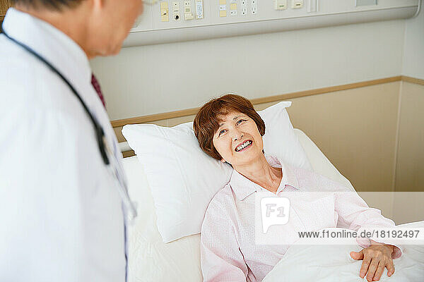Japanese senior woman being examined by a doctor in a hospital room