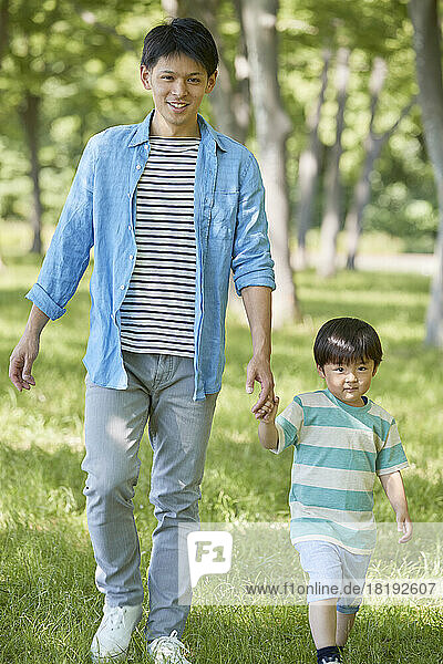 Japanese parent and child walking in the fresh greenery