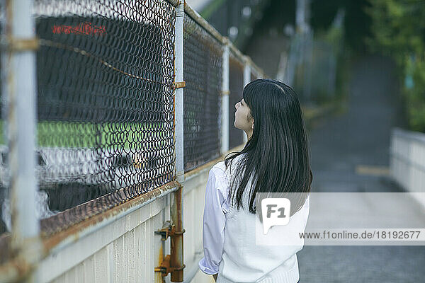 Japanese high school girl on a pedestrian bridge