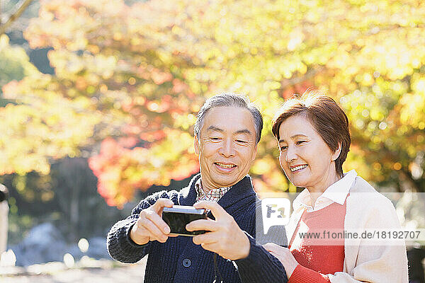 Senior Japanese couple traveling in the autumn leaves season