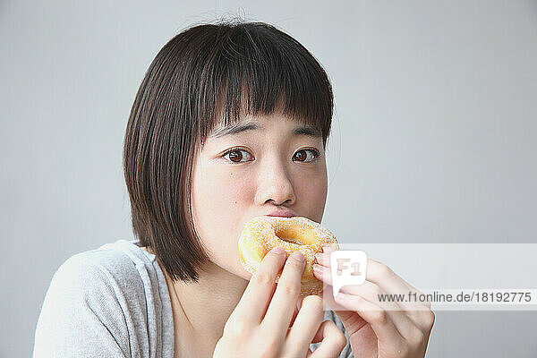Young Japanese woman eating a donut
