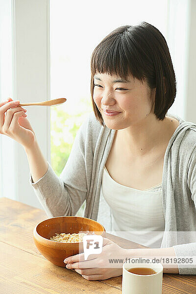 Young Japanese woman eating breakfast