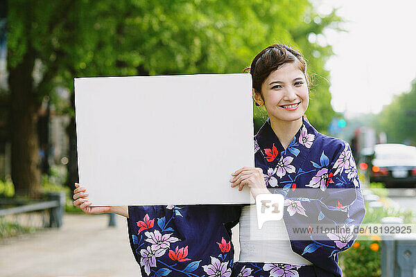 Japanese woman in a yukata holding a whiteboard