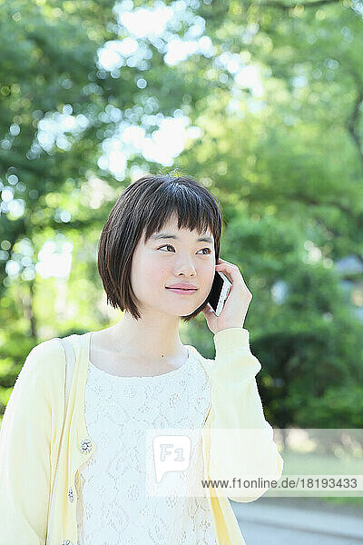 Young Japanese woman making a call on a mobile phone