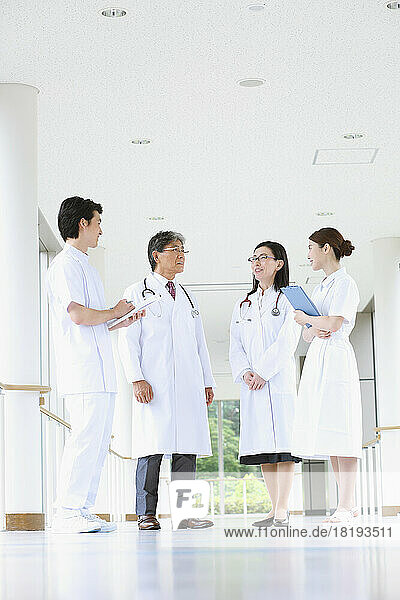 Smiling medical team having a conversation in the hallway