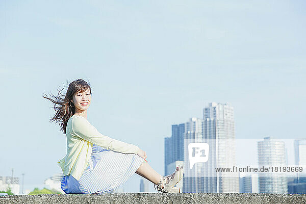 Japanese woman sitting on the sea barrier