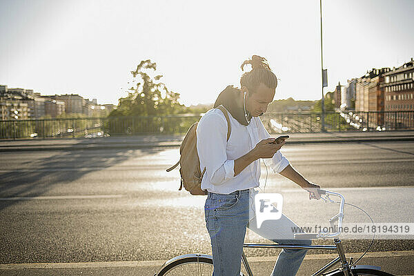 Man with bicycle using smartphone