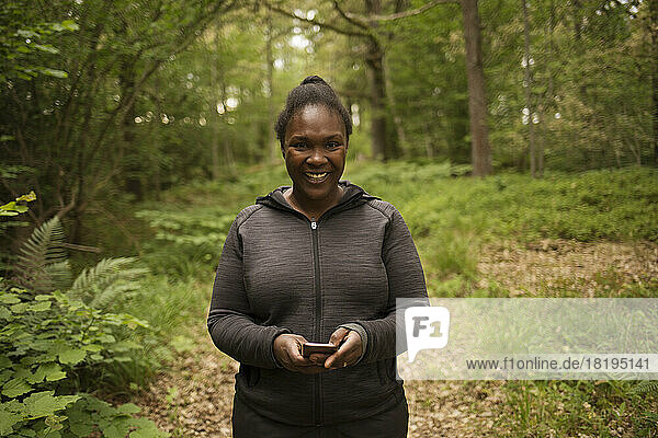Smiling woman hiking in forest