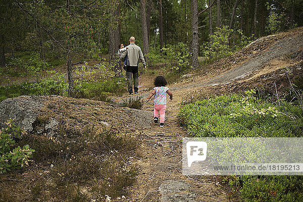 Man hiking with his daughters in forest