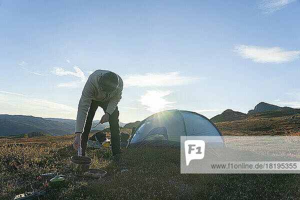 Young man camping with tent on mountain