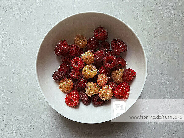 View from above fresh  juicy red raspberries in bowl