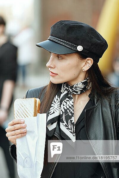 Attraktives Mädchen isst Sandwich auf der Straße