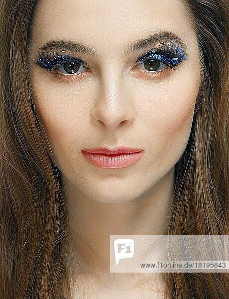 Closeup portrait of girl with creative makeup with sparkles on the eyes