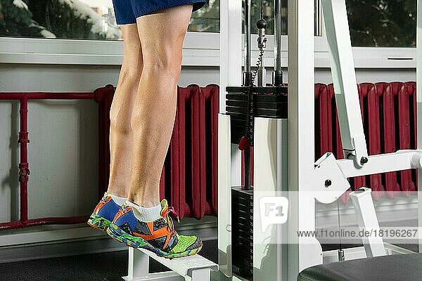 Tiptoe exercises with heavy weight  male legs close up