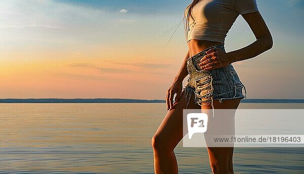 Unerkennbare Frau mit schlanker Figur posiert gegen Sonnenuntergang am Strand