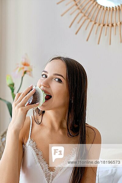 Closeup portrait of a girl eating sponge cake with creamy topping