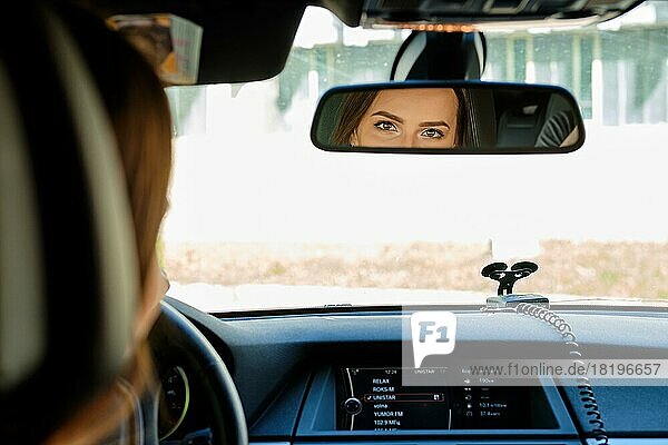 Reflexion der weiblichen Augen im Rückspiegel eines Autos