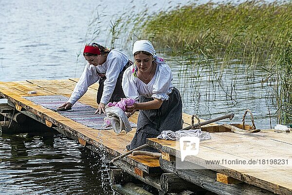 Traditionell gekleidete Frauen beim Händewaschen  Unesco-Stätte Insel Kizhi  Karelien  Russland  Europa