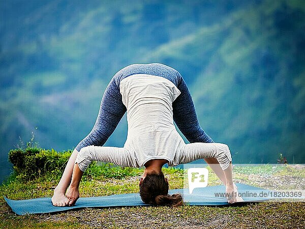 Yoga-Übung im Freien  Frau macht Ashtanga Vinyasa Yoga asana Prasarita padottanasana D  breitbeinige Vorwärtsbeuge-Pose im Freien. Vintage Retro-Effekt gefiltert Hipster-Stil Bild