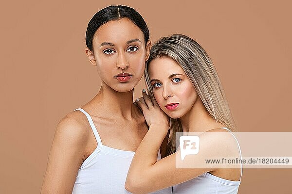 Schöne kaukasische und afrikanische junge Frauen mit unterschiedlichen Hauttypen